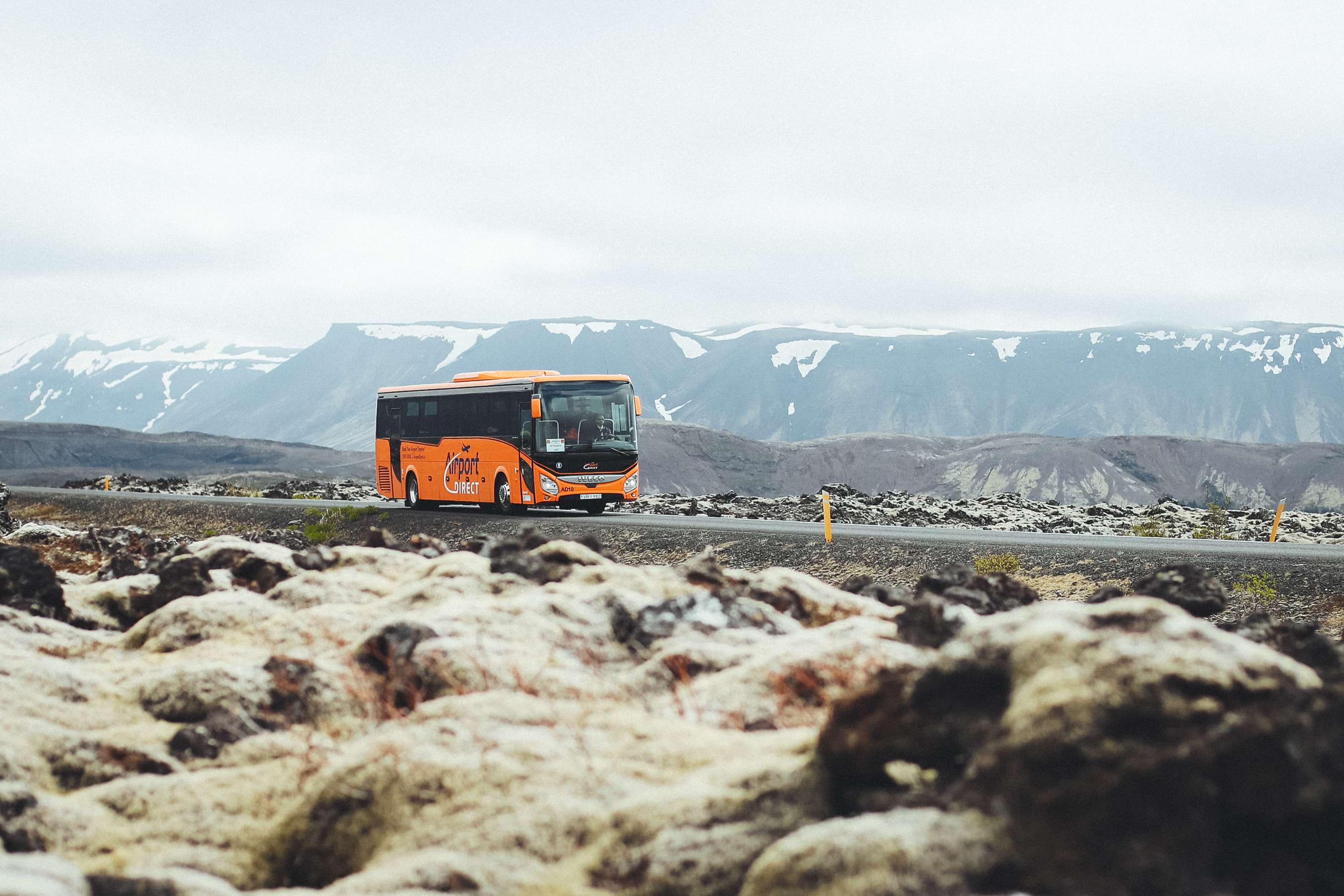 Airport Direct Bus with snow covered mountains in the background