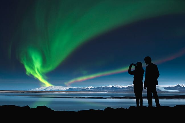 two people photographing northern lights