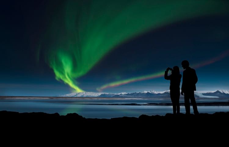 two-people-photographing-northern-lights-with-camera-phone