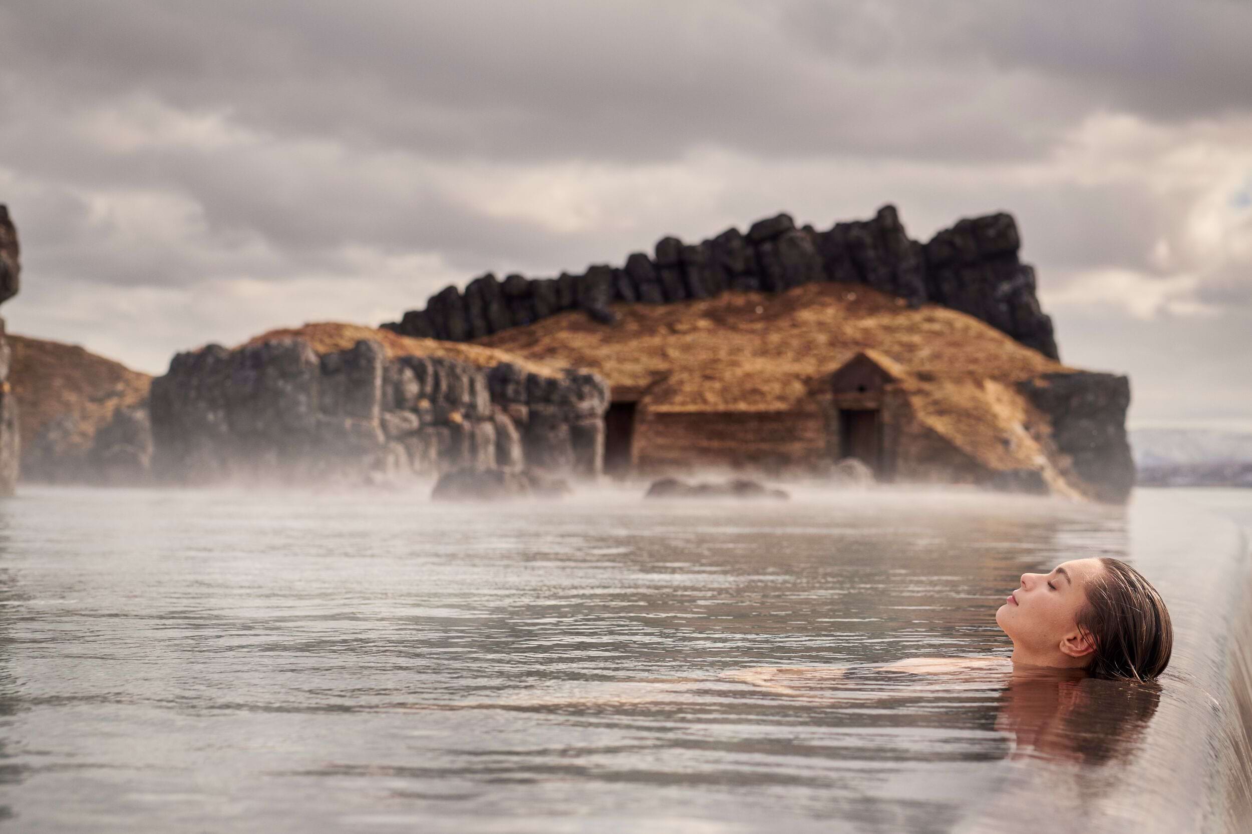 A woman floating in the infinity pool in the Sky Lagoon in Iceland